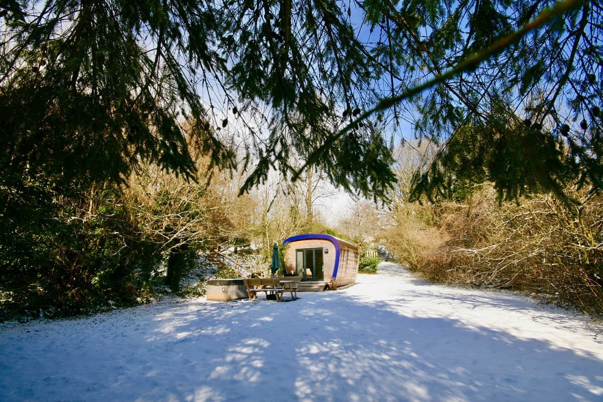 Serene and picturesque scene of the Ecopod nestled in the snow-covered garden