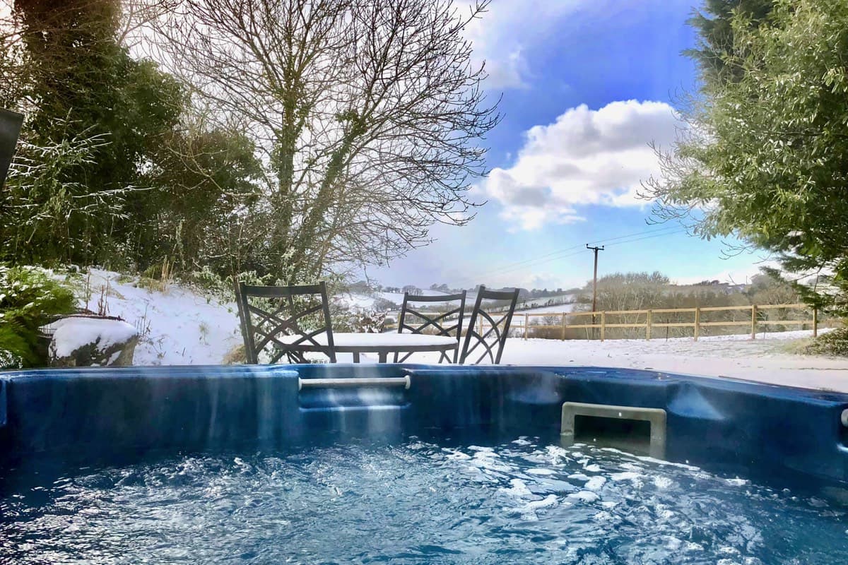Winter bliss: Relaxing in the hot tub amidst a snowy landscape at Sunridge Lodge