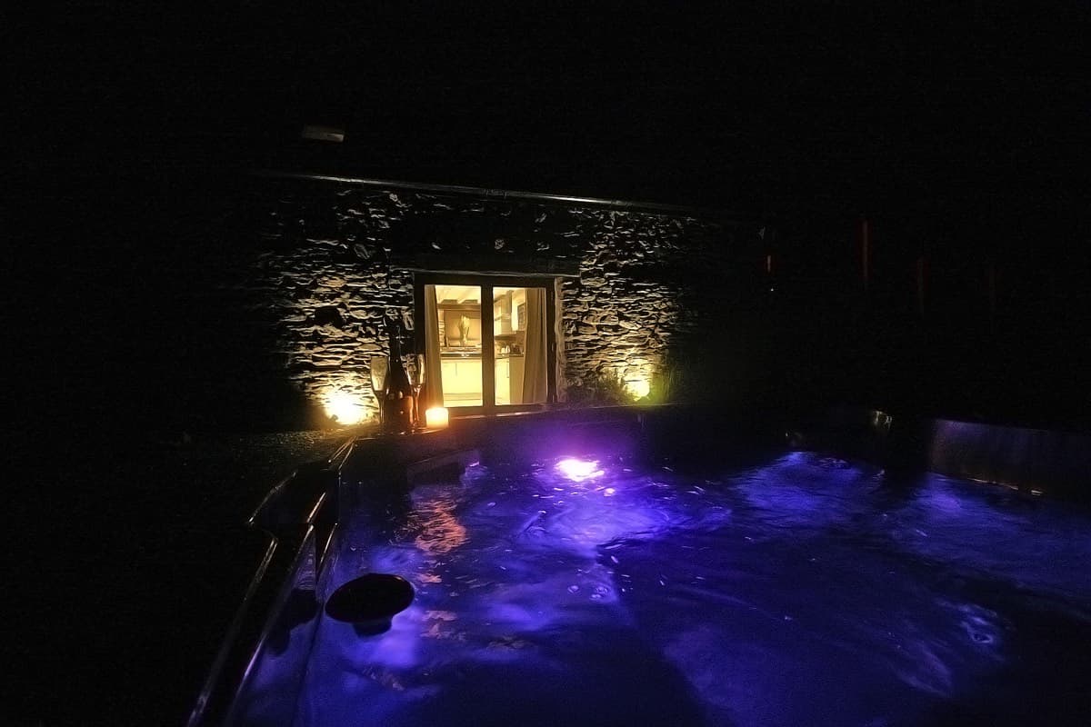 Unwinding in the tranquil hot tub under the night sky at Sunridge Retreats