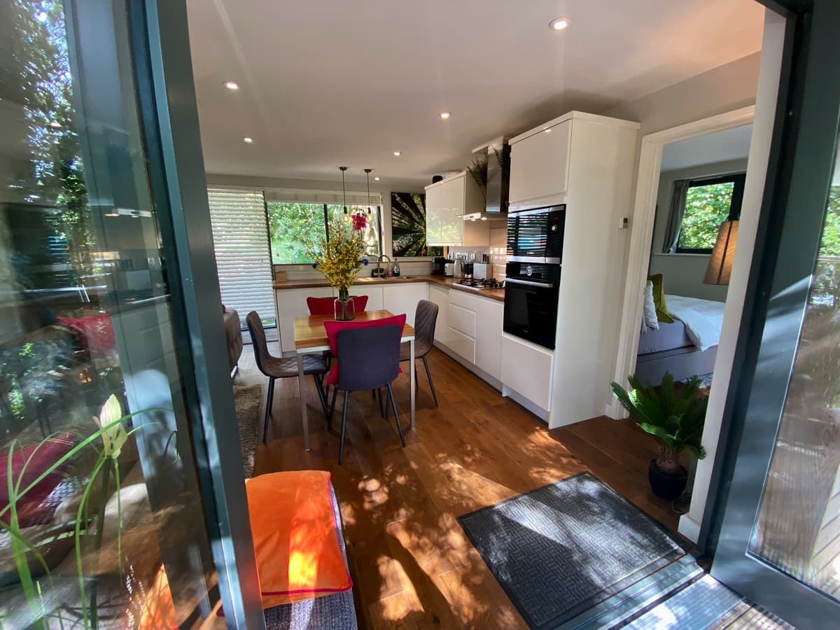 Treehouse kitchen seamlessly connecting to the upper deck through open bifolds, inviting the outdoors in.